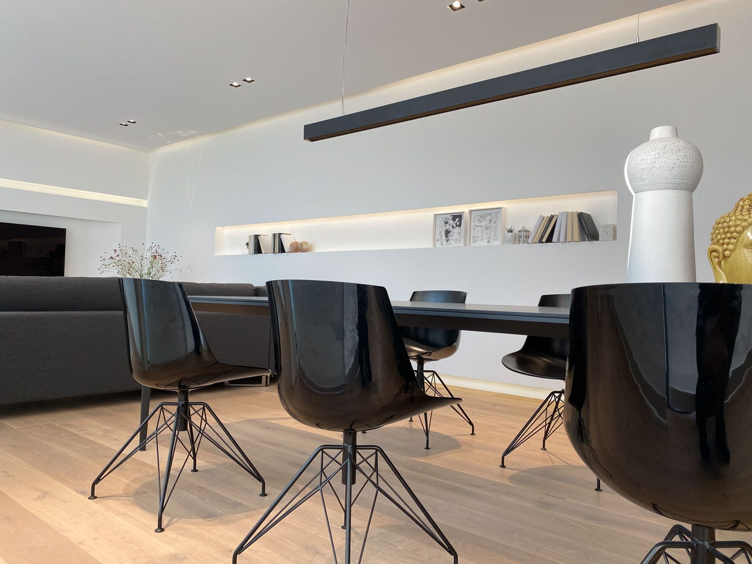 Sala da pranzo minimalista a Villa MD Home, design di Federico Cappellina & Partners Architects. Tavolo nero allungabile e sedie di design in un ambiente luminoso e accogliente
