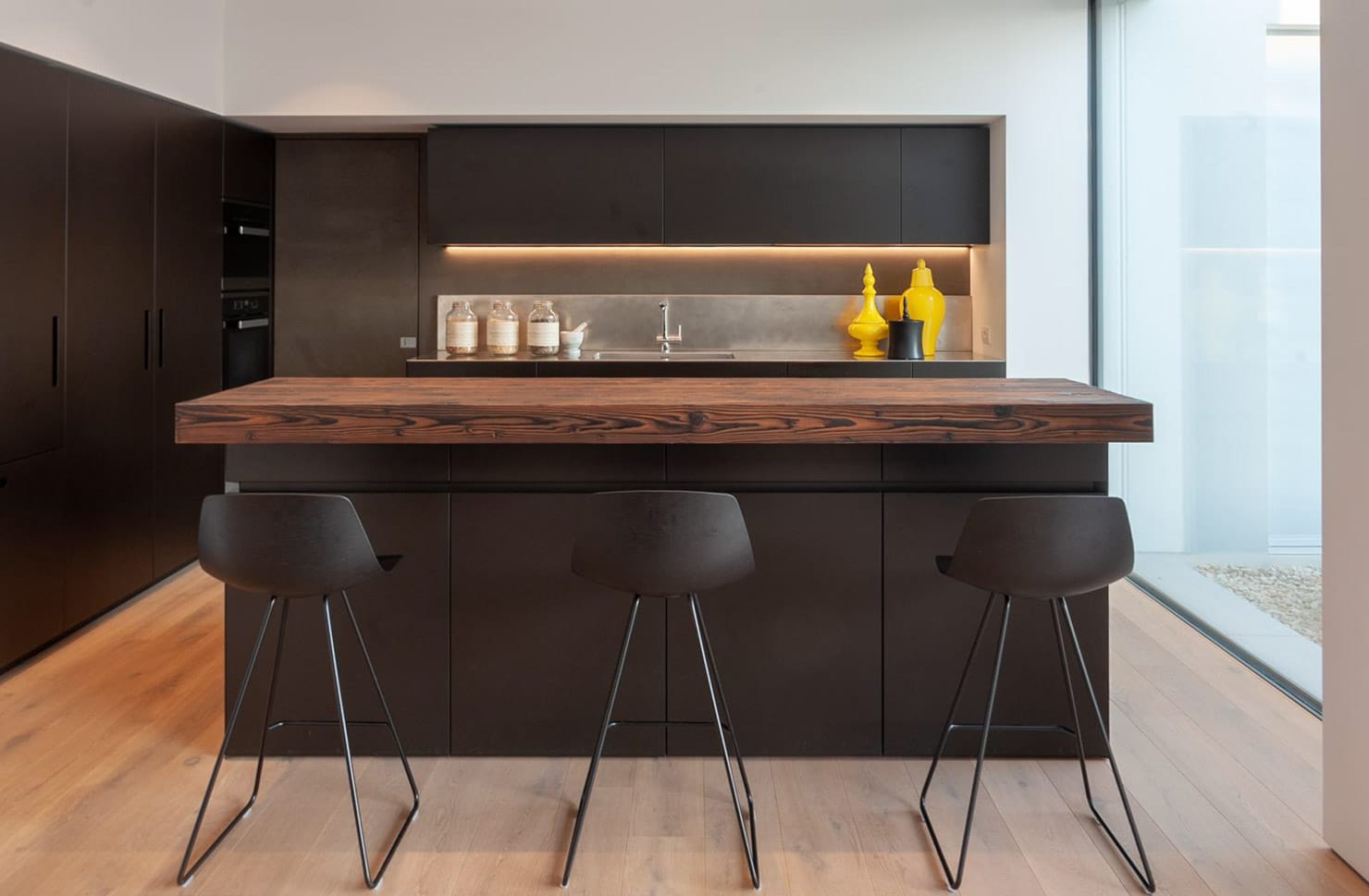 Cucina moderna con isola in legno massello a Villa MD Home, design di Federico Cappellina & Partners Architects. Arredi minimalisti e illuminazione curata per un ambiente elegante e funzionale