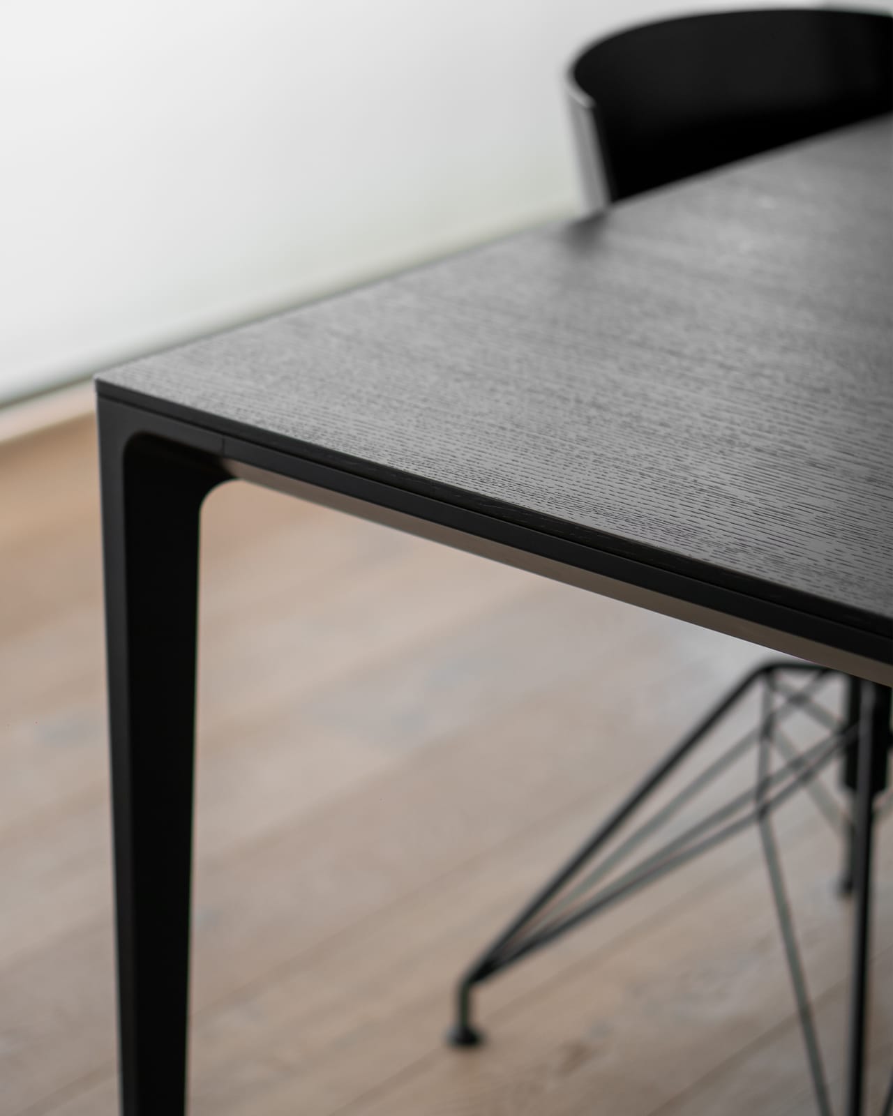 Dettaglio del tavolo da pranzo nero minimalista a Villa MD Home, Verona, con piano in legno scuro e gambe in metallo. Design di lusso firmato Federico Cappellina & Partners Architects