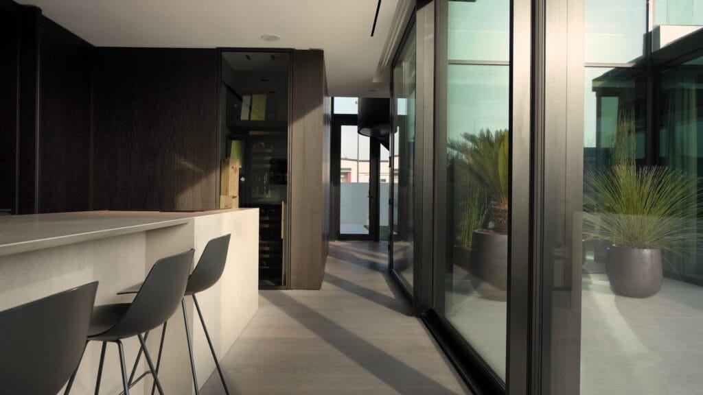 Interni ville di lusso 2 Cucina con isola in pietra naturale, sgabelli e arredi fissi scuri su misura, AV Home