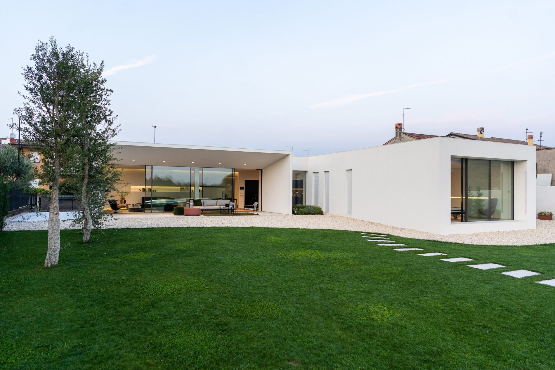 Il giardino al tramonto con la villa e le vetrate illuminate