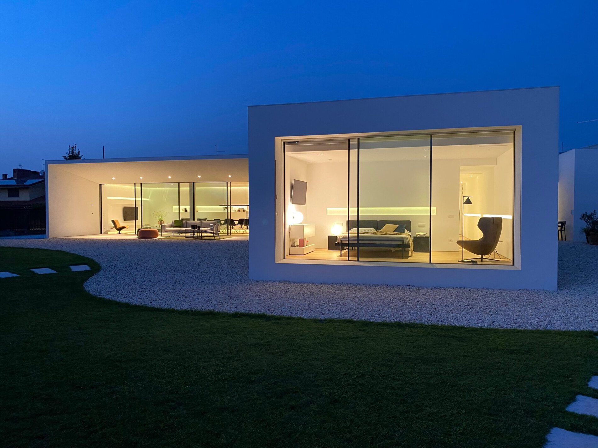 La villa di notte con la vetrata illuminata e il giardino